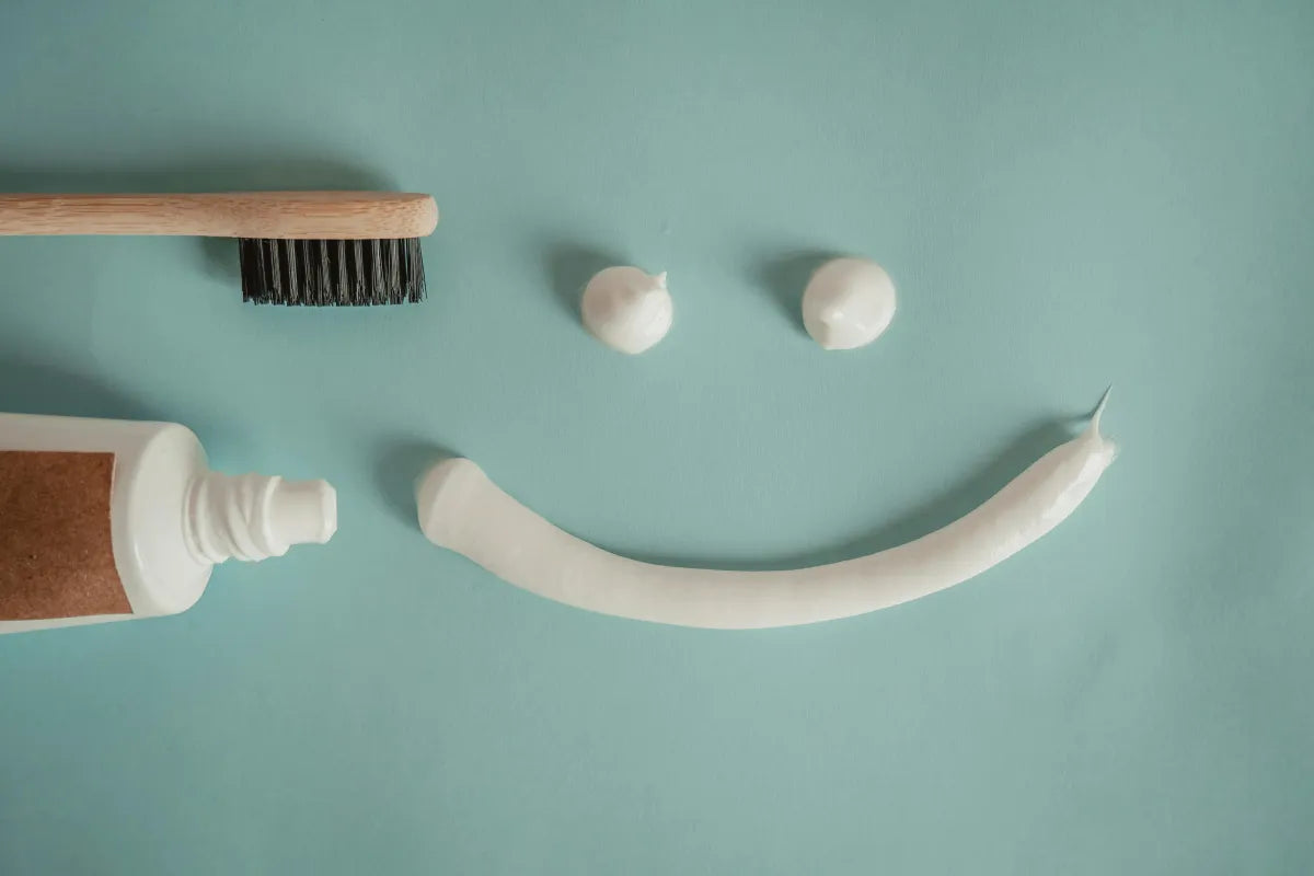 eco-friendly oral care products including charcoal toothpaste and toothbrush, and fresh mint.