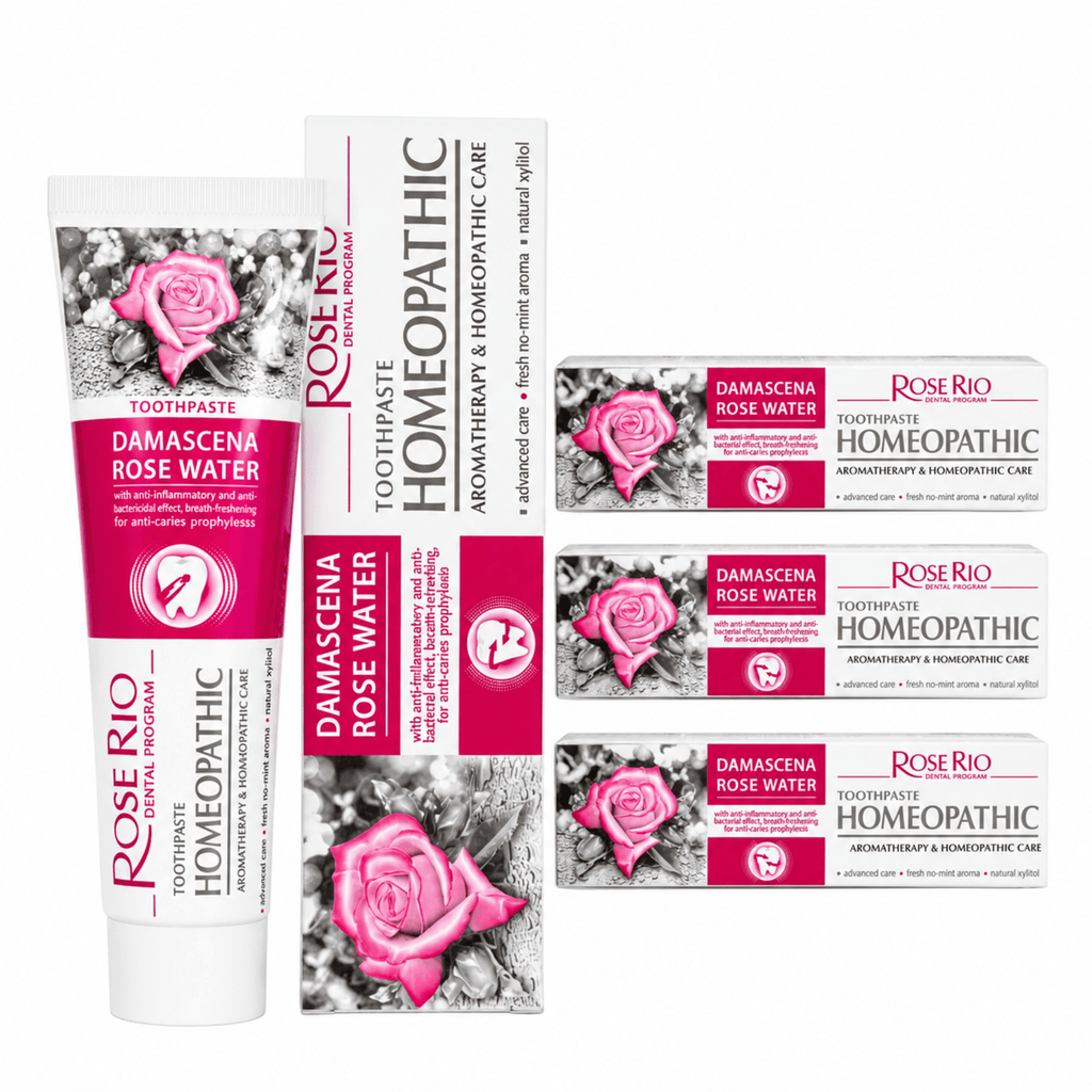 A 3-pack bundle of Rose Rio Homeopathic Toothpaste in Damascena Rose Water, featuring a tube and boxes on a reflective surface. The packaging denotes exact therapeutic claims: aromatherapy, anti-inflammatory, breath-refreshing, and anti-caries prophylaxis. Formulated with natural xylitol and a fresh no-mint aroma. Supplied by UK oral care retailer Edinco.